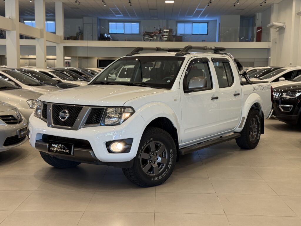 A NISSAN-FRONTIER SV ATTACK Cabine Dupla 2.5 Turbo Diesel 4x4 2014 representa um dos momentos mais sólidos da segunda geração da picape média da marca japonesa no mercado brasileiro. Produzida em São José dos Pinhais (PR), esta versão específica tornou-se um verdadeiro ícone de custo-benefício e robustez na época. A linha Attack nasceu inicialmente como uma série especial, mas o sucesso de vendas foi tamanho que a Nissan a transformou em uma versão definitiva de catálogo.